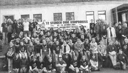 Gruppenfoto mit Aktionstransparent vor dem Pfarrheim Niederfischbach